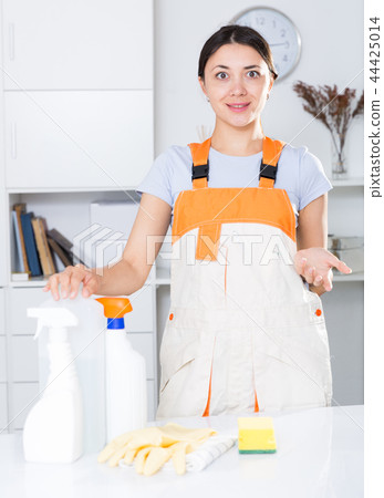 Young woman in uniform standing before cleaning in office Young woman in uniform standing before cleaning in office 44425014