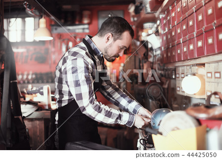 Worker preparing buckle for belt Worker preparing buckle for belt 44425050