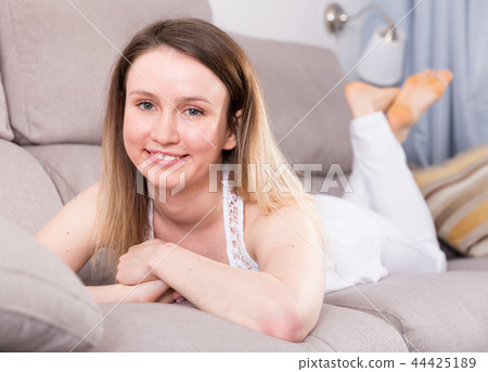 Cheerful girl is lying on sofa and playful posing Cheerful girl is lying on sofa and playful posing 44425189