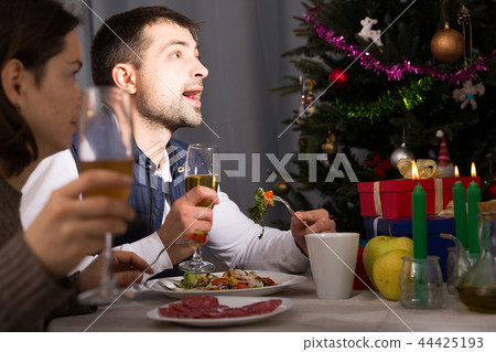 Couple having christmas dinner and watching tv 44425193