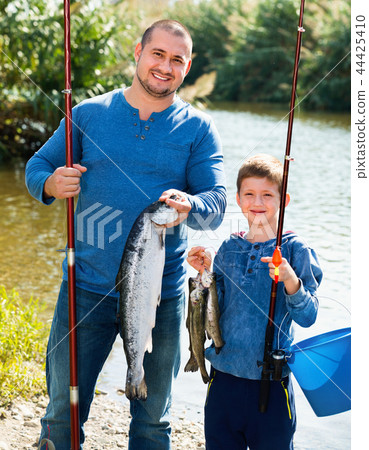 Portrait of father and son fishing with rods 44425410