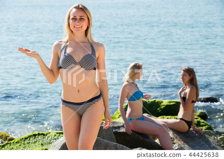 young woman in bikini standing on beach 44425638
