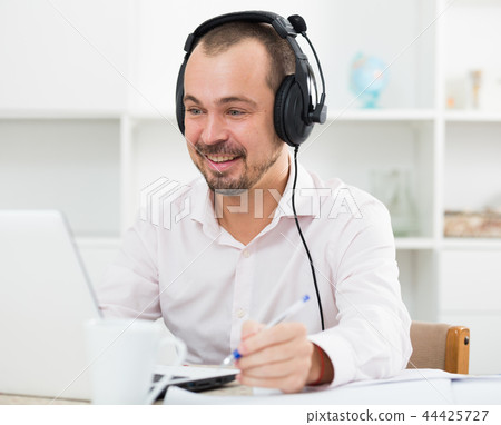 Positive man in headphones near computer 44425727