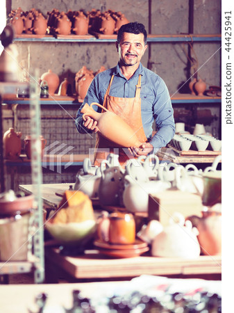 Male artisan in ceramics workshop. 44425941