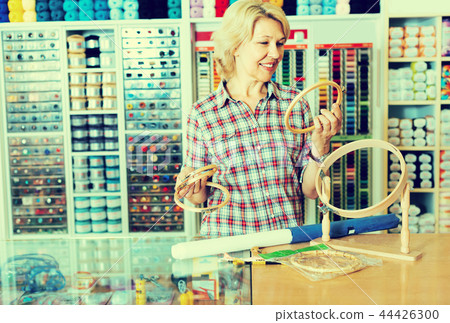mature woman at counter in sewing store. mature woman at counter in sewing store. 44426300