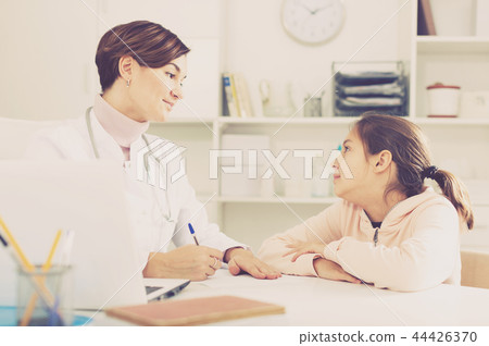 Doctor fills patient card for girl 44426370