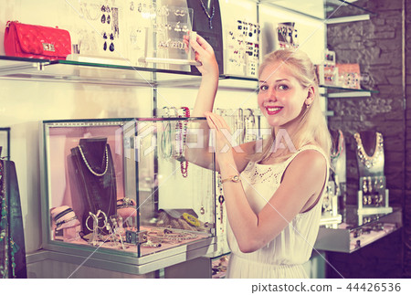 Woman standing near showcase in bijouterie boutique Woman standing near showcase in bijouterie boutique 44426536