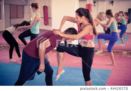 Sporty girl with her instructor are training self-defence moves in gym. 44426578