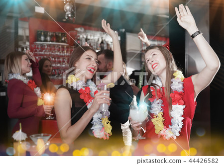 Female colleagues on company party in Hawaiian style in bar Female colleagues on company party in Hawaiian style in bar 44426582