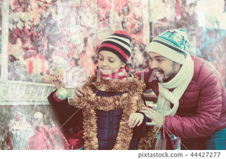 Nice man with small daughter with Christmas garlands Nice man with small daughter with Christmas garlands 44427277