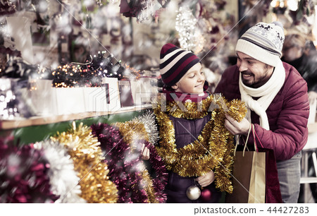 Little girl with dad buying decorations for Xmas Little girl with dad buying decorations for Xmas 44427283