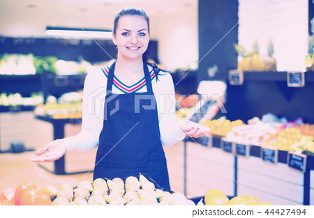 Shopping assistant demonstrating assortment of grocery shop Shopping assistant demonstrating assortment of grocery shop 44427494
