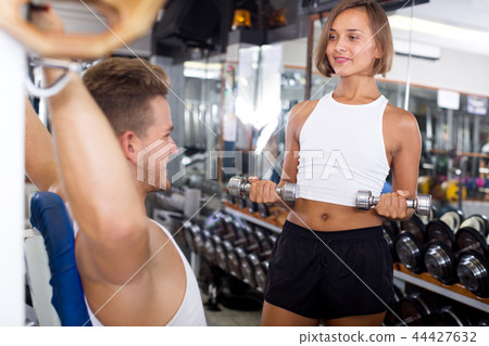 Woman training hands using weight dumbbells Woman training hands using weight dumbbells 44427632
