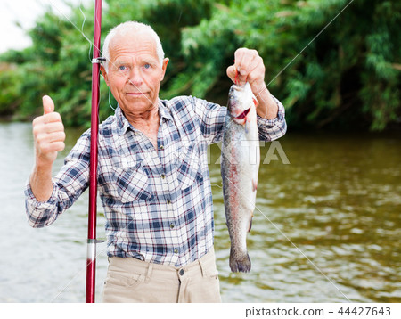 Fisherman holding fresh catch fish Fisherman holding fresh catch fish 44427643