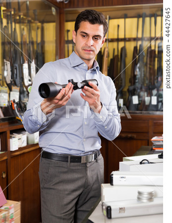 Confident man looking for optical sights 44427645