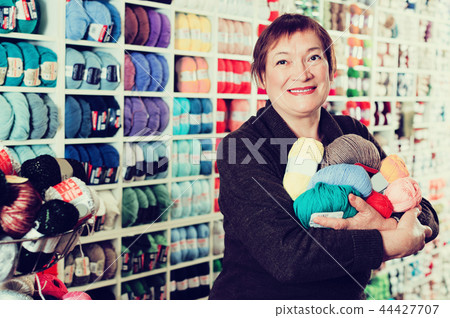 Woman holding colorful knitting yarns 44427707