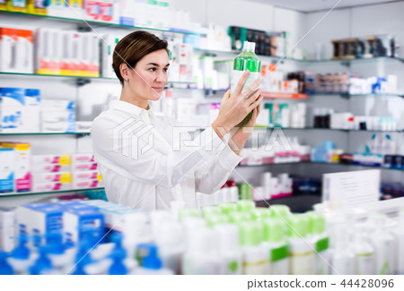 Positive woman customer browsing rows of drugs Positive woman customer browsing rows of drugs 44428096