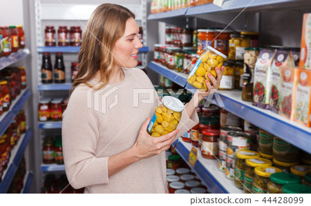 Woman customer choosing pickle goods in the food store Woman customer choosing pickle goods in the food store 44428099