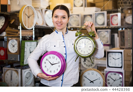 Attractive woman is standing with modern clock Attractive woman is standing with modern clock 44428398