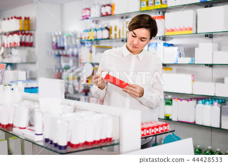 Female is browsing rows of body care products 44428533