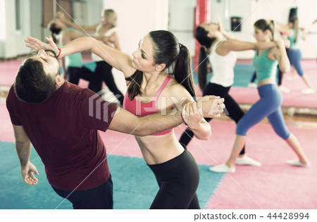 Sporty girl with her instructor are training self-defence moves Sporty girl with her instructor are training self-defence moves 44428994