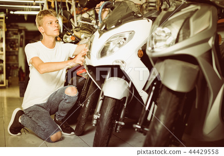 Portrait of adult man purchaser choosing motorbike Portrait of adult man purchaser choosing motorbike 44429558