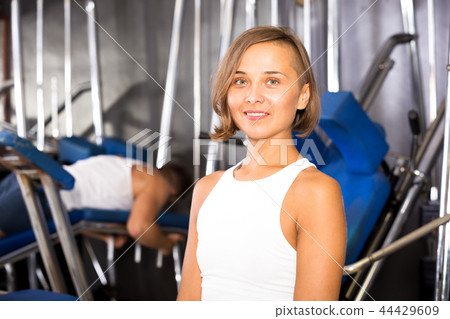 Woman sitting on bench between exercises in gym Woman sitting on bench between exercises in gym 44429609
