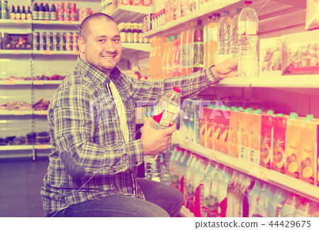 man choosing mineral water in grocery. 44429675
