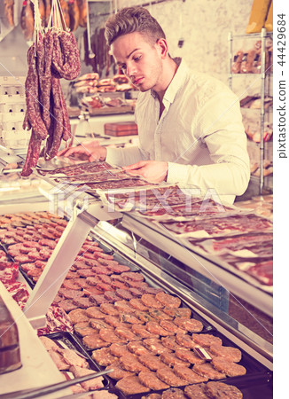 interested young male customer at butcher store 44429684