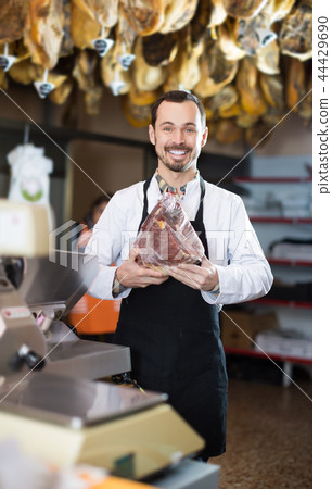 Positive male assistant showing piece of meat 44429690