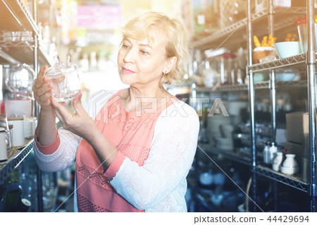 customer female choosing glass sugar bowl in the dishes shop customer female choosing glass sugar bowl in the dishes shop 44429694
