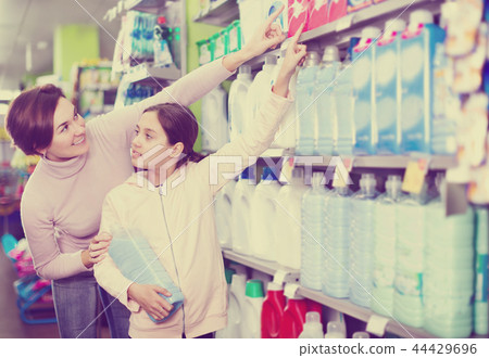Woman with girl looking for cleaners in supermarket 44429696