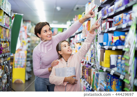 Woman customer with girl looking for tasty cookies Woman customer with girl looking for tasty cookies 44429697