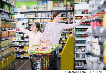 Laughing woman and daughter with shopping cart 44429703