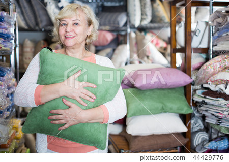 Adult female buyer choosing colour pillows 44429776