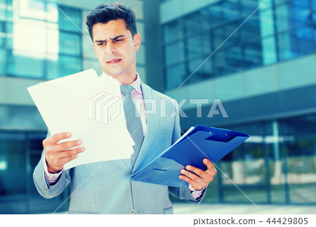 Serious manager reading papers Serious manager reading papers 44429805