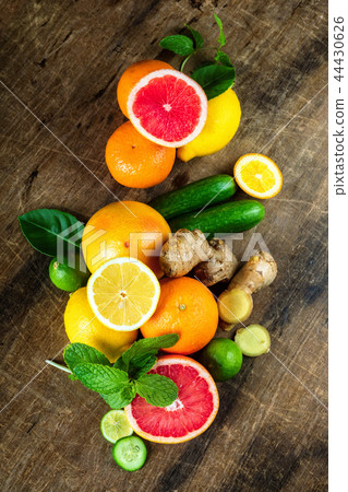 Raw fruit whole and cut on wooden background Raw fruit whole and cut on wooden background 44430626