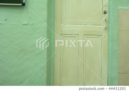 Background is an old white door and a green Background is an old white door and a green 44431201