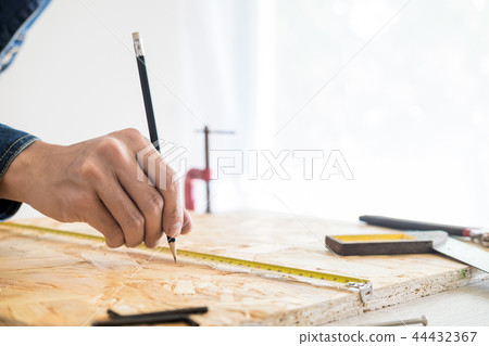 Carpenter working carefully looking at the plans work in carpent 44432367