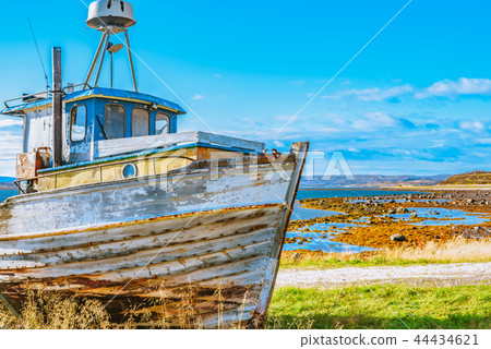 Bright old abandoned fishing boat on the coast 44434621