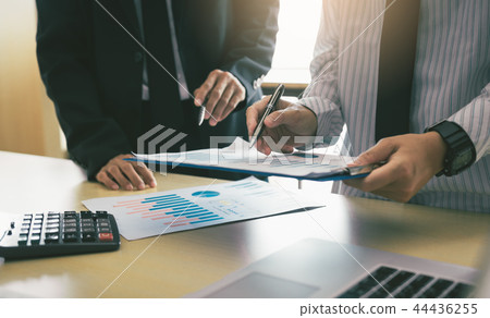 Business worker discussing finance graphs report a Business worker discussing finance graphs report a 44436255