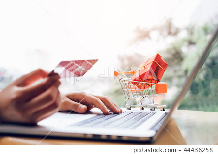 Woman holding credit card and typing keyboard Woman holding credit card and typing keyboard 44436258