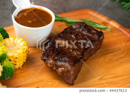 Grilled beef steak with spices on cutting board Grilled beef steak with spices on cutting board 44437613