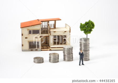 Real estate concept: miniature businessman with house and coin 44438165
