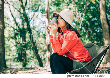 Woman drinking coffee at campsite Woman drinking coffee at campsite 44438839