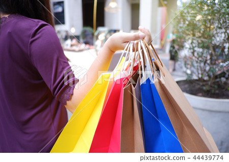 Women holding colorful bags, enjoying shopping. 44439774