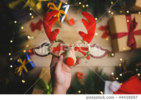 Hand Holding Christmas Reindeer Glasses 44439897