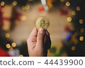 Hand Holding Bitcoin Above Christmas Decoration 44439900