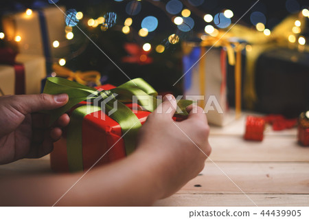 Hand Tying Up Red Green Christmas Present Gift 44439905