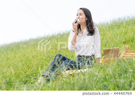 A woman who eats a rice ball 44440769